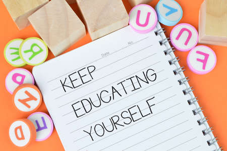 Top view of notebook written with text KEEP EDUCATING YOURSELFの写真素材