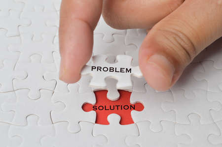 Management concept with hand holding piece of jigsaw puzzle with PROBLEM and SOLUTION wording.の写真素材