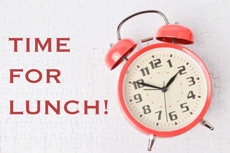 Top view of clock isolated on white background written with TIME FOR LUNCH!