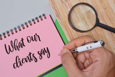 Notebook written with text WHAT OUR CLIENTS SAY. Business concept