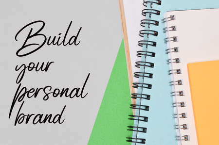 Top view of notebooks over green and white background written with BUILD YOUR PERSONAL BRAND....