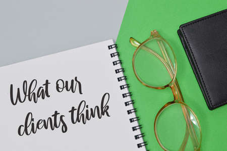 Notebook written with text WHAT OUR CLIENTS THINK. Business concept.