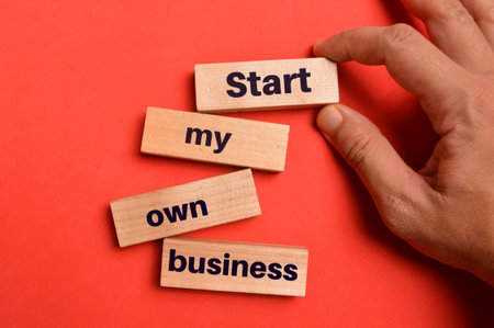 Top view of wooden blocks written with START MY OWN BUSINESS.の写真素材