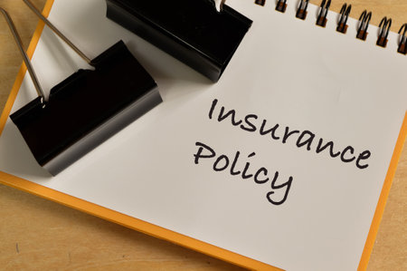 Phrase INSURANCE POLICY written on notebook with paper clips.の写真素材