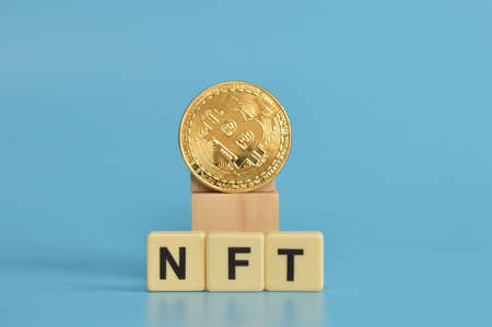 Golden bitcoin and alphabet letters with text NFT stands for Non Fungible Tokens.の写真素材