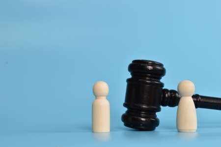 Wooden doll figures standing with judge gavel. Bribery and corruption concepts.の写真素材