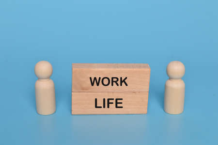 Wooden doll figures and wooden blocks written with WORK and LIFEの写真素材