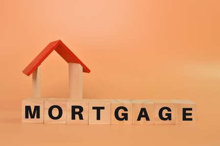 Toy house and wooden cubes with text MORTGAGE.の写真素材
