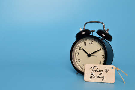 Alarm clock and label tag written with TODAY IS THE DAYの写真素材