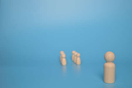 Wooden doll leader stands distantly from the crowd of wooden figures. Leader and leadership concept.の写真素材