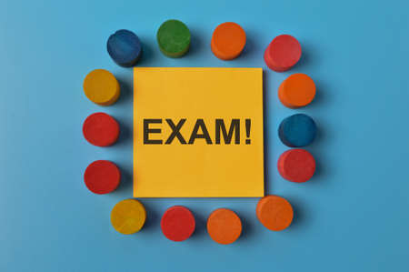 Top view of colorful wooden blocks and memo note written with EXAM!の写真素材