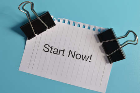 Top view of white paper written with START NOW!の写真素材