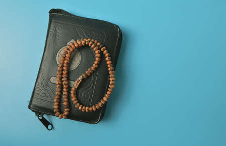 Holy quran or koran with prayer beads isolated on blue backgroundの写真素材