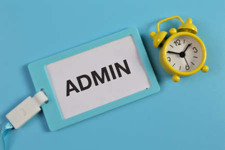 Top view of alarm clock and name tag written with ADMIN.の写真素材