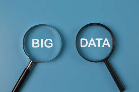 Top view of magnifying glass written with BIG DATA isolated on blue background