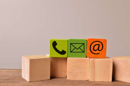 Customer support concept. Colorful wooden blocks with email, phone and mail icons.の写真素材