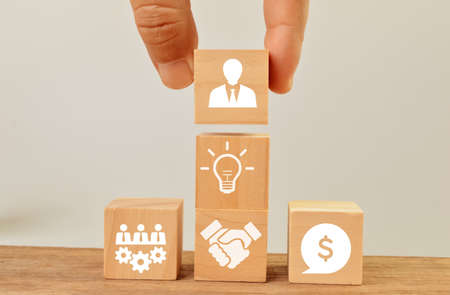Wooden cubes with teamwork, hand shake, money, bulb and businessman icons. Concept of business...