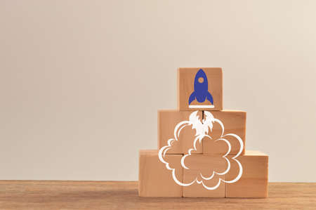 Wooden blocks with launching rocket. Business start up, new idea and new project concept.