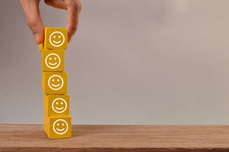 Wooden blocks with smile face icons. Customer evaluation and satisfaction concept