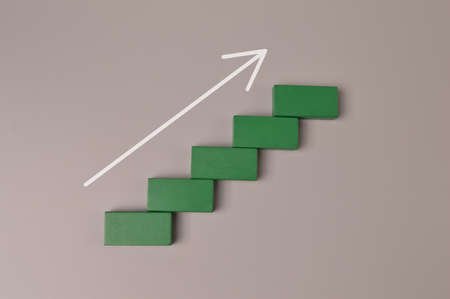 Wooden blocks with arrow pointing upward. Business start up and economic growth concept.の写真素材