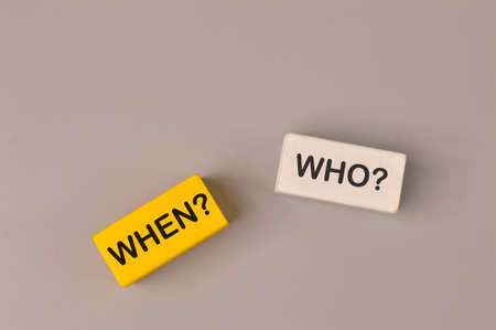 Wooden blocks written with WHEN? and WHO?の写真素材