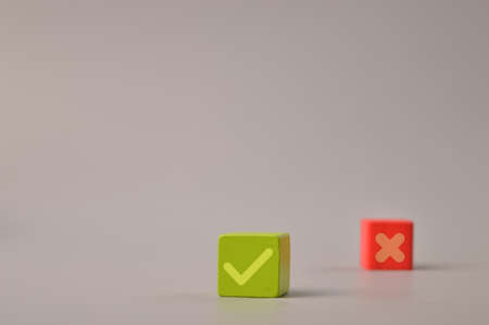 Wooden blocks with check mark and x symbols on wooden blocks. Correct and wrong concept.の写真素材