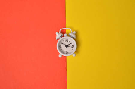 Alarm clock isolated on yellow and red background