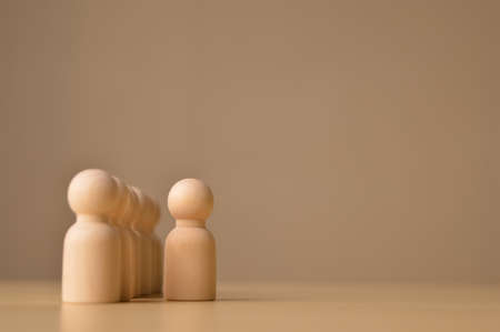 Wooden doll figure standing out from the crowdの写真素材
