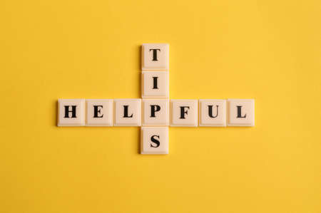 Square letters with text HELPFUL TIPS isolated on yellow backgroundの写真素材
