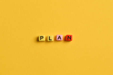Alphabet letters with text PLAN isolated on yellow background