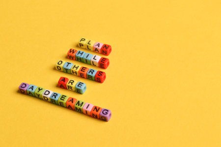 Alphabet letters with text PLAN WHILE OTHERS ARE DAYDREAMINGの写真素材