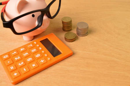 Calculator, stack of coins and piggy bank. Copy spaceの写真素材