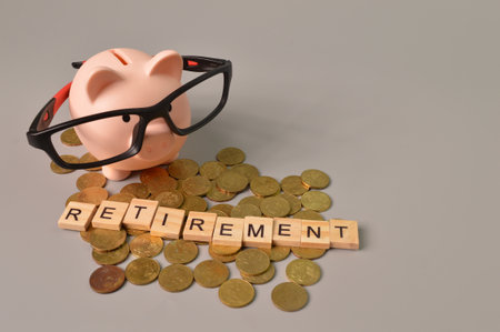 Stack of coins, piggy bank and wooden blocks with text RETIREMENT.の写真素材