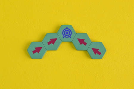 Target goal with arrow symbols on wooden blocks