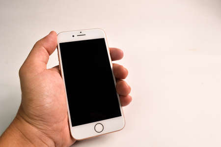 Klang, Malaysia: July 20, 2021- Hand holding iphone 8 isolated on white backgroundのeditorial素材