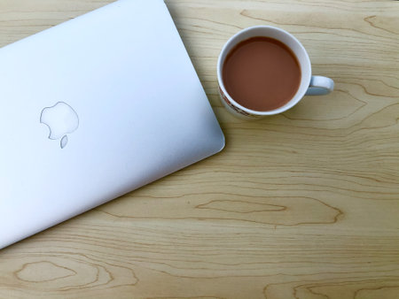 Klang, Malaysia: July 21st, 2021- Macbook Air and hot milk tea on the table. Copy space.のeditorial素材