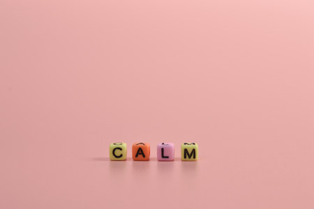 Colorful alphabet beads with text CALM isolated on pink backgroundの写真素材