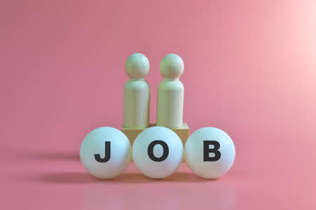 Wooden people figures with text JOB isolated on pink backgroundの写真素材