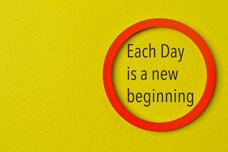 Phrase EACH DAY IS A NEW BEGINNING on yellow background. Motivational and inspirational concept.