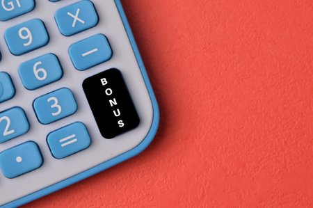 Top view of calculator with text BONUS isolated on red backgroundの写真素材