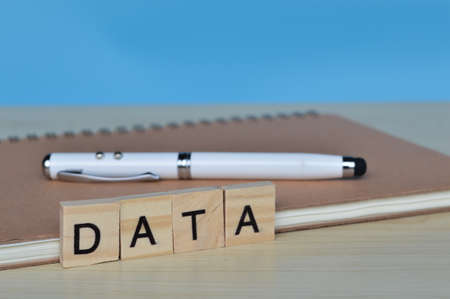 Front view of pen, book and wooden blocks with text DATAの写真素材