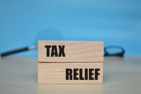 Wooden blocks with the words TAX RELIEF. Blurred background