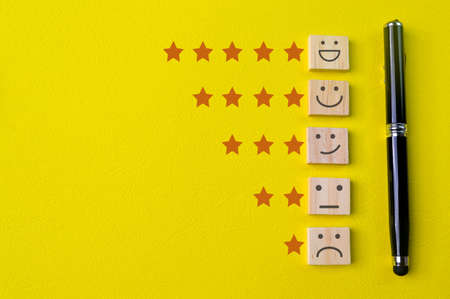 Face emotions with star ratings isolated on yellow backgroundの写真素材