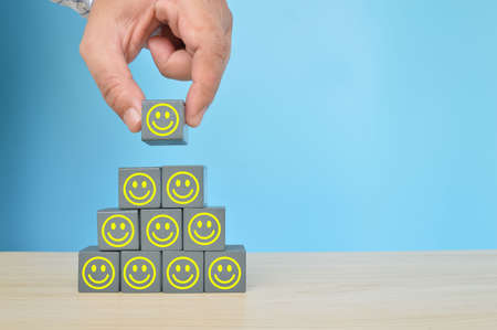 Wooden cube blocks with smile emotion. Customer feedback and satisfaction conceptの写真素材
