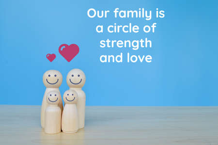 Wooden doll figures standing with phrase OUR FAMILY IS A CIRCLE OF STRENGTH AND LOVEの写真素材