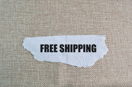 Ripped paper with text FREE SHIPPING isolated on a brown backgroundの写真素材