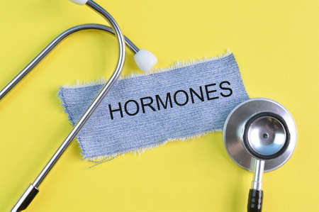 Stethoscope and ripped pieces of jeans with text HORMONESの写真素材