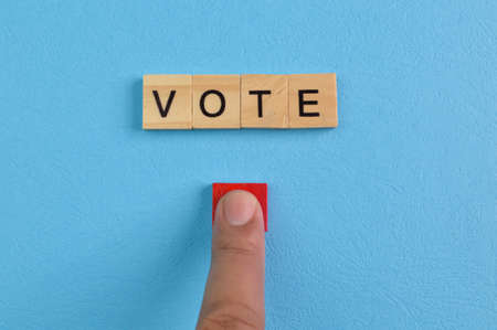 Text VOTE with finger push pointing at wooden blockの写真素材