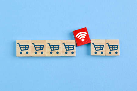 Wooden block with shopping cart and wifi symbols. Online shopping and E-commerce concept