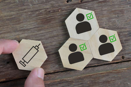 Wooden cube blocks with vaccinated people against COVID-19